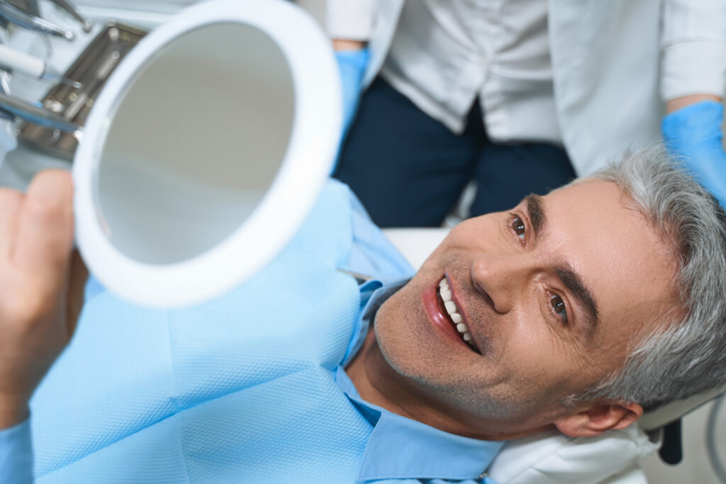 A male patient smiling after receving veneers from a premier Silver Spring Dentistry
