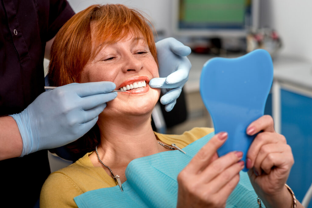 an elderly patient getting a manual dental cleaning while smiling at a Silver Spring dental clinic